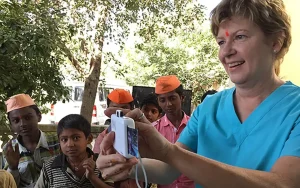 A woman showing Indian children a picture